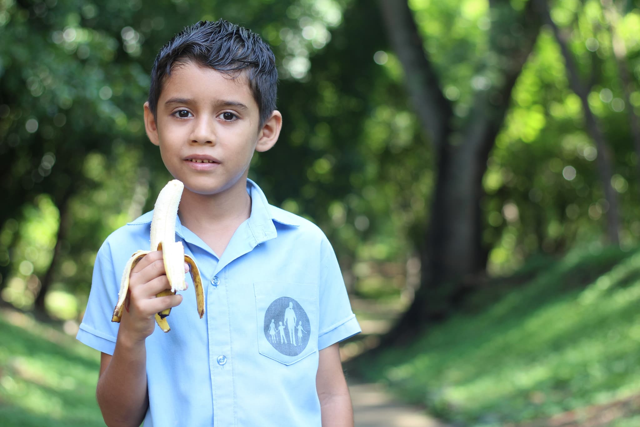 Junge mit einer geschälten Banane in der Hand.