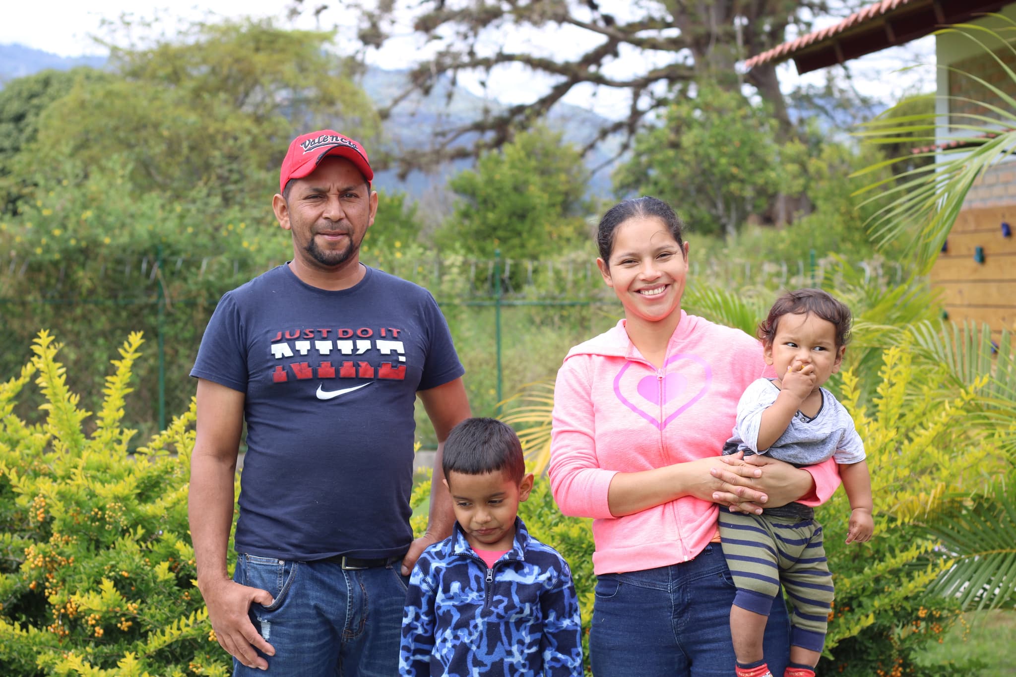 Familie mit zwei Kindern in einem Garten