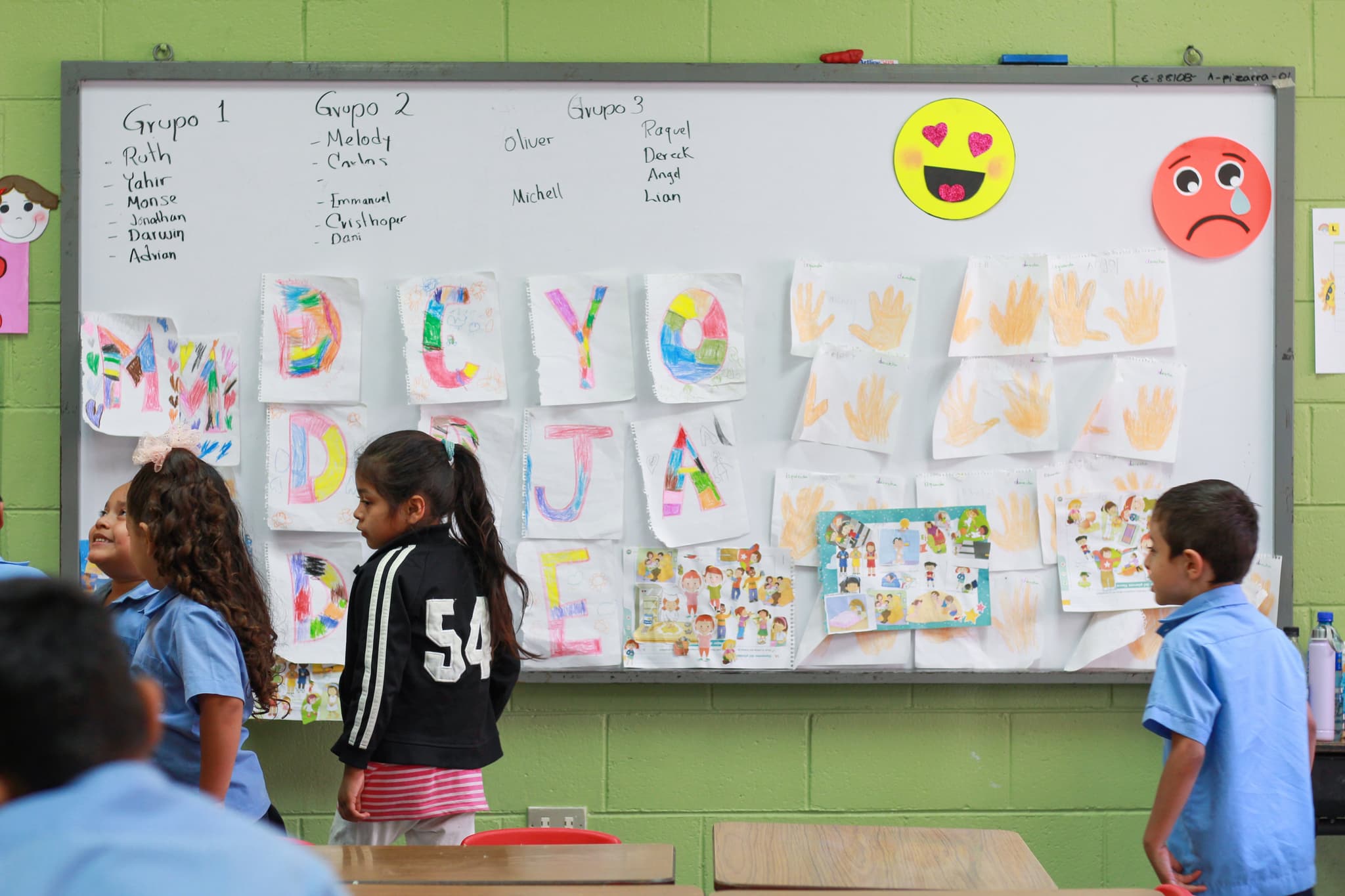 Kinder stehen im Kindergarten vor einer Lerntafel