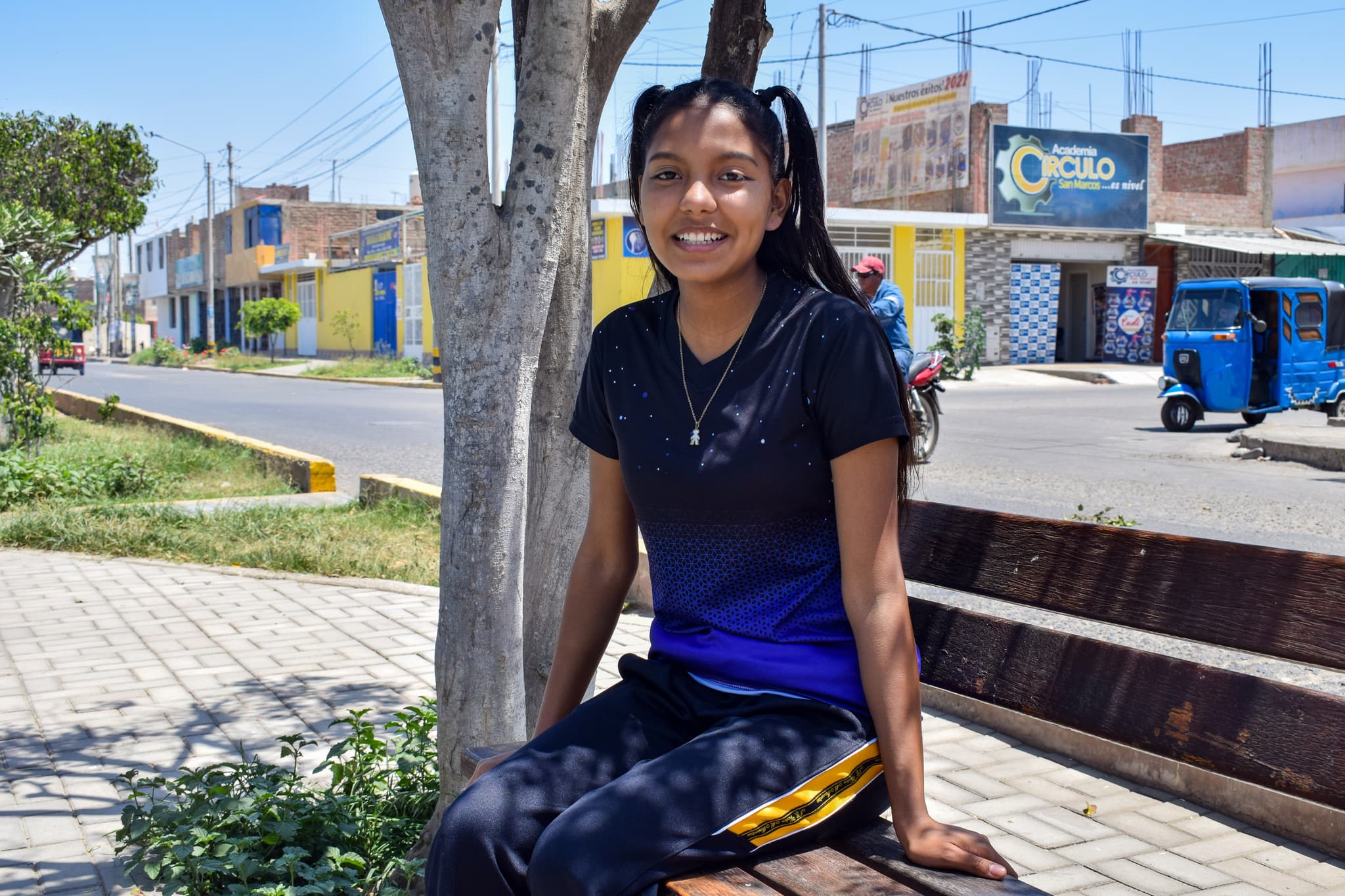 Mädchen, das auf einer Bank in einer Stadt in Peru sitzt.