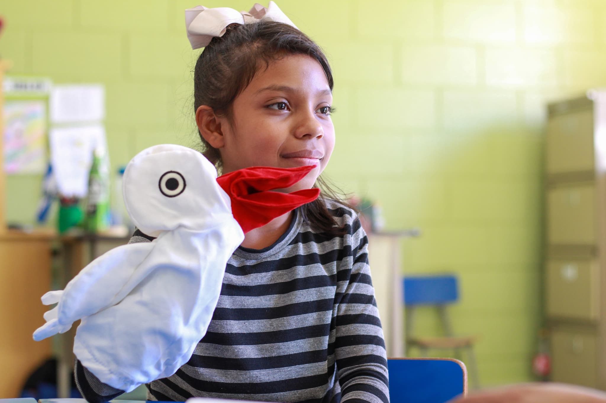 Rina spielt mit einer Storchenhandpuppe