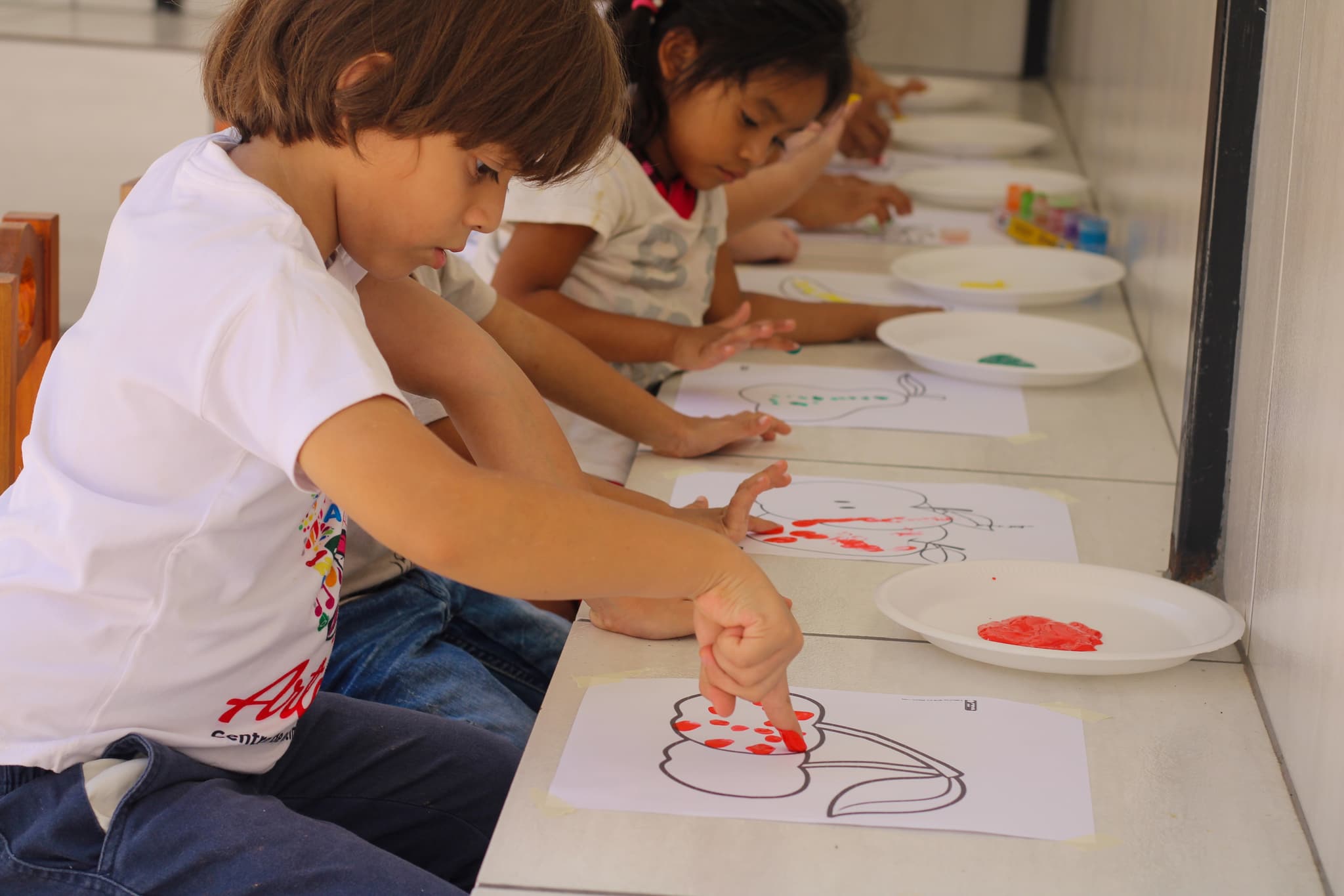 Enrique in der Kindertagesstätte beim Zeichnen mit seinen Freunden